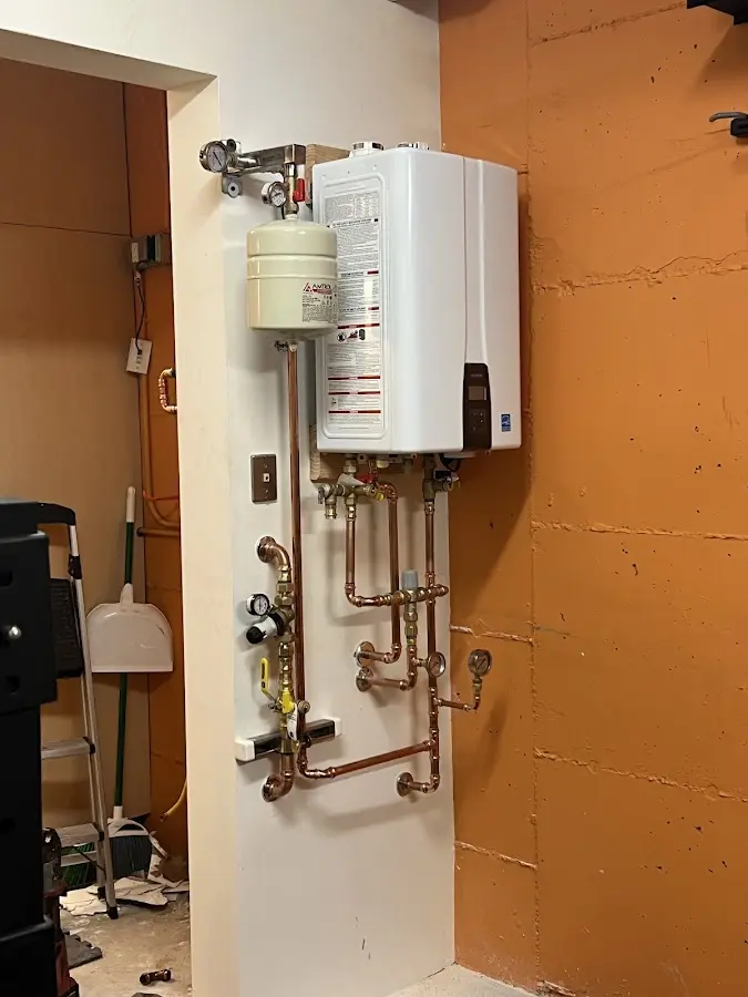Plumbing technician inspecting water heater connections in Hampton
